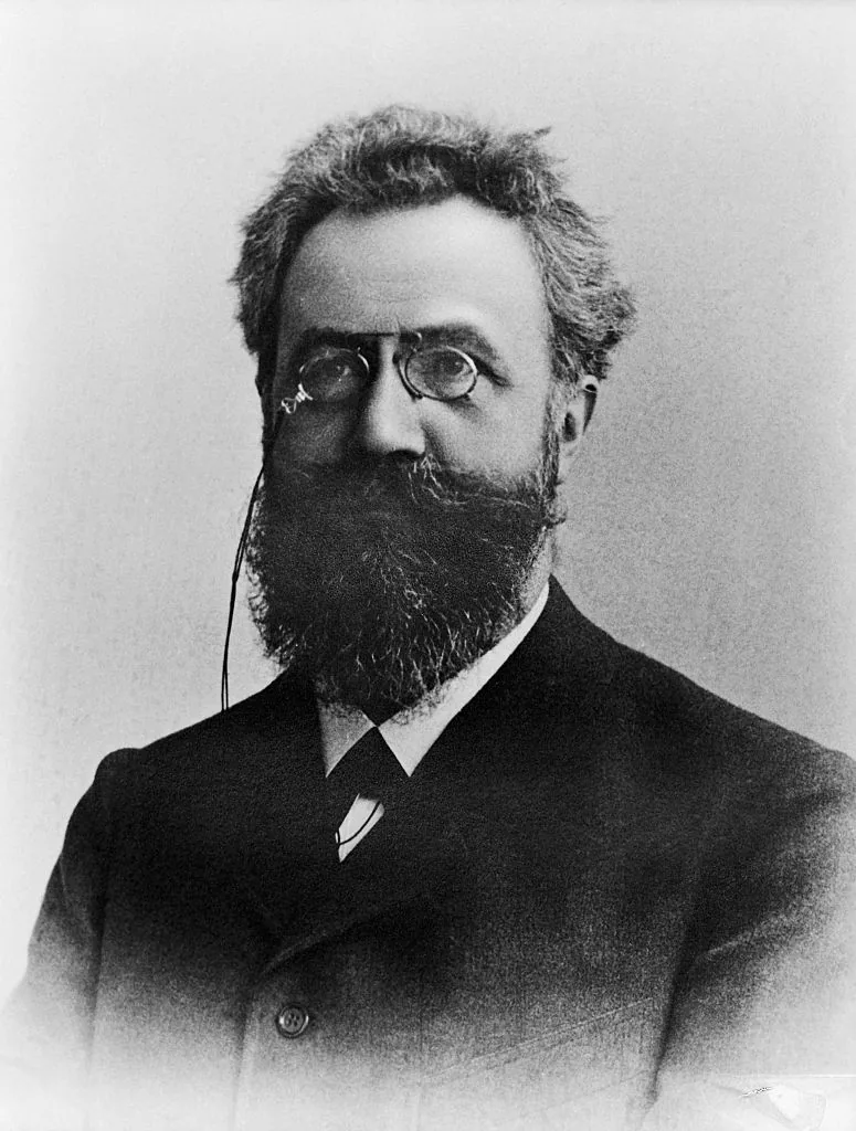 Retrato em preto e branco de Hermann Ebbinghaus, homem de barba cheia e pincenê, de terno escuro.
