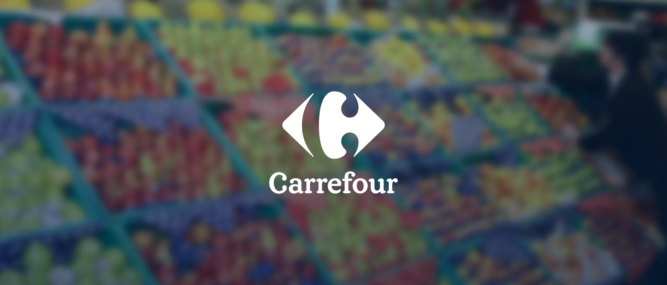 Logotipo do Carrefour sobre uma gôndola de frutas desfocada